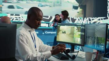 African american dispatch operator gives directions and gps coordinates of the location to the delivery truck driver, following the orders on satellite map. Employee monitors traffic. Camera B. video