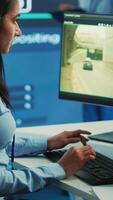 verticale Indien femme opérateur localisation livraison un camion et des offres GPS coordonnées de le expédition emplacement. contrôle centre employé consulte Satellite carte et vidéosurveillance système pour itinéraires. caméra un. video