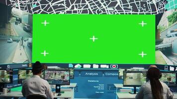 Group of employees monitoring delivery trucks routes with an isolated screen, working with satellite map and radar. Diverse people look at greenscreen display, order tracking. Camera B. video