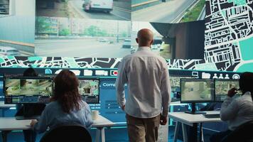 Diverse call center operators monitoring couriers in traffic and update clients on potential order delay due to busy routes. Employees guiding the delivery cars via gps and satellite map. Camera B. video