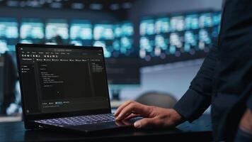 IT support employee typing on notebook keyboard to ensure optimal performance in data center. Close up shot of laptop used by worker monitoring energy consumption across servers video