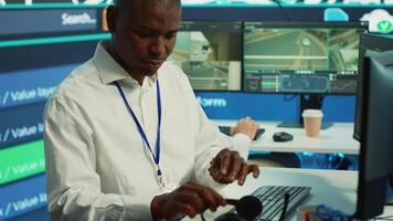 African american dispatch operator gives directions and gps coordinates of the location to the delivery truck driver, following the orders on satellite map. Employee monitors traffic. Camera A. video