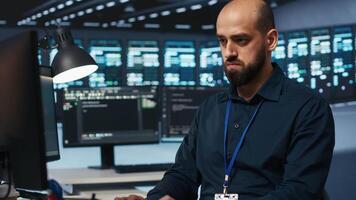 System administrator in server hub coding, ensuring data remains shielded from threats. IT developer safeguarding supercomputers against unauthorized access, securing system from hackers video
