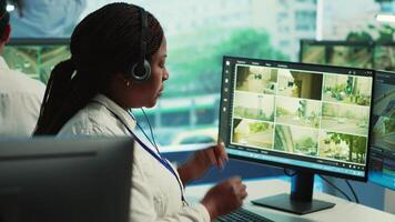 African american employee monitoring traffic activity in the city by using CCTV system to ensure public safety. Woman watches real time surveillance footage in government observation room. Camera A. video