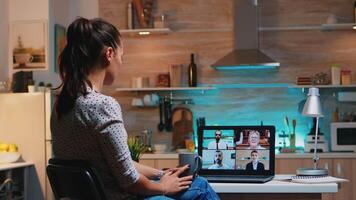 mulher queda adormecido durante conferência em computador portátil trabalhando a partir de casa atrasado às noite dentro a cozinha. usando moderno tecnologia rede sem fio falando em virtual encontro às meia noite fazendo hora extra video