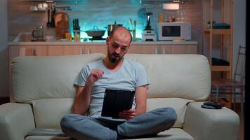 Focused man having online meeting videocall on tablet computer speaking using videoconference online web internet communication. Caucasian man browsing on internet for deadline project video