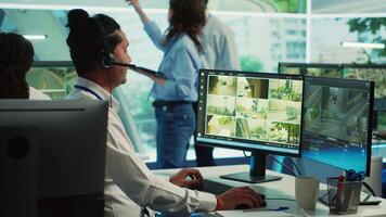 Indian employee communicating satellite map directions in observation room, monitoring traffic around the city via CCTV security system. Young man works with surveillance data. Camera A. video