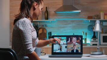 frilansare vändning av de bärbar dator under webinar i de mitten av konferens Sammanträde i de kök arbetssätt sent på natt avlägset. använder sig av modern teknologi nätverk trådlös video