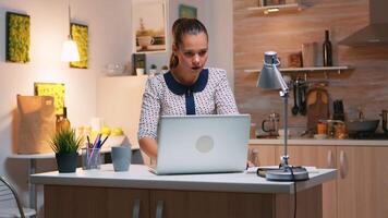 Excited woman feel ecstatic reading great online news on laptop working from home kitchen. Happy employee using modern technology network wireless doing overtime studying writing, searching video