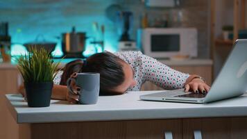 femme d'affaires qui travaillé jusqu'à ce que minuit sur projet abattage endormi sur bureau travail de Accueil avec main sur clavier. employé en utilisant moderne La technologie réseau sans fil Faire heures supplémentaires en train de dormir sur tableau. video