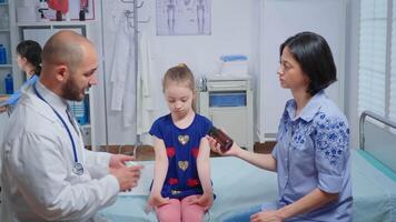 barnläkare ger mor en flaska av piller för barn sjukdom. sjukvård praktiker läkare läkare specialist i medicin tillhandahålla hälsa vård service samråd behandling i sjukhus skåp video