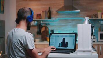 Man designer using cad software to design a 3D concept of buildings working overtime from home. Industrial male employee studying prototype idea on personal computer looking on device display video