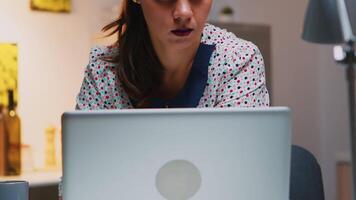 retrato de mujer de negocios pensando de correo electrónico responder trabajando a hogar sentado en cocina escritorio. cerca arriba de ocupado empleado utilizando moderno tecnología red inalámbrico haciendo tiempo extraordinario leyendo escribiendo, buscando video