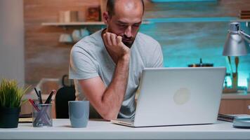 estresado joven negocio hombre dormido en frente de ordenador portátil en hogar cocina. ocupado agotado remoto empleado siesta en silla despertar arriba trabajando en ordenador portátil tiempo extraordinario utilizando moderno tecnología red inalámbrico video