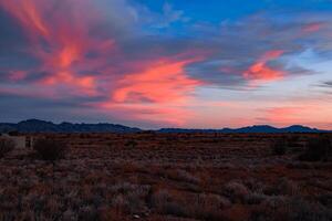 Crimson Sky Over Desert Terrain photo