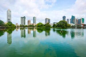 View of Colombo cityscape and skyscrapers reflection on Beira Lake a lake in the center of the city. Colombo is the commercial capital and largest city of Sri Lanka. photo