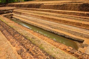 A pool in the garden complex of Sigiriya palace Sri Lanka. Sigiriya has water gardens a complex hydraulic system, which consists of canals, lakes, dams, fountains, as well as underground water pumps. photo