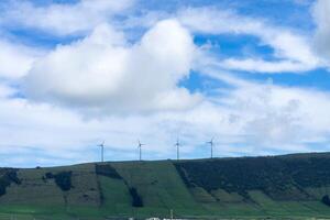 Iconic wind turbines stand tall amidst the scenic beauty of Serra do Cume mountain in Terceira Island, Azores. Clean energy in a picturesque setting. photo