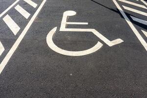 discapacitado estacionamiento firmar pintado en suelo. símbolo indicando reservado estacionamiento espacio para individuos con discapacidades concepto de accesibilidad y inclusión. foto