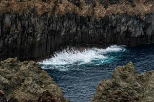 Waves crashing against dramatic cliffs on Terceira Island, Azores. Captivating natural beauty captured in one breathtaking moment. photo