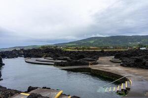 Stunning natural pools of Biscoitos, Terceira Island, Azores, nestled amidst black volcanic rocks formed by eruptions. photo