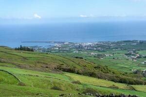 Aerial view of Porto Martins on Terceira Island, Azores, with the vast Atlantic Ocean as backdrop. Stunning coastal landscape captured from above. photo