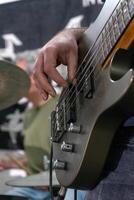 un hombre jugando un bajo guitarra en un casual ajuste. él es enfocado en su instrumento, dedos deslizamiento terminado el instrumentos de cuerda. su relajado postura y casual atuendo sugerir un relajado música sesión. foto