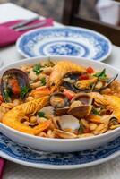 A traditional Alentejo restaurant serves a vibrant seafood feijoada. This dish features prawns, shellfish, and beans in a rustic clay pot, offering a hearty and authentic Portuguese experience. photo