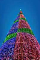 Artificial Christmas tree in garlands at twilight. photo