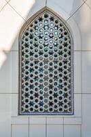 The window of a Muslim mosque behind bars in the form of a geometric hexagonal Islamic ornament. photo