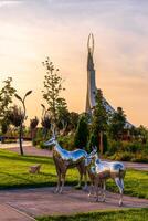 UZBEKISTAN, TASHKENT - SEPTEMBER 15, 2023 Monument of Independence in the form of a stele with a Humo bird on a twilight with dramatic cliods in the New Uzbekistan park. photo