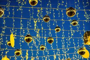 nuevo año o Navidad festivo dorado pelotas colgando en filas en contra el noche cielo. foto