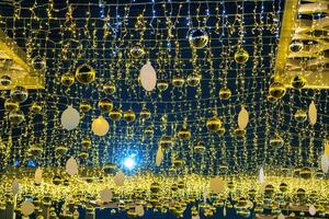 New Year or Christmas festive golden balls hanging in rows against the night sky. photo