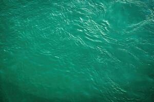 The texture of the waves of turquoise color of fast-flowing water in the river. photo