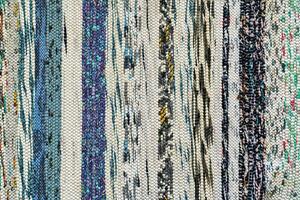 Texture of a multi-colored wicker floor carpet close-up. Abstract background. photo