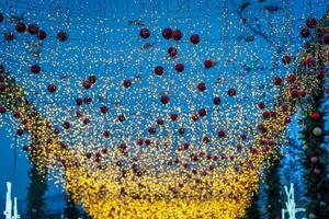 New Year or Christmas festive balls and garlands hanging in rows against the night sky. photo