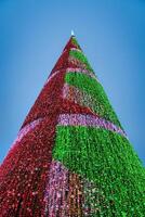 Artificial Christmas tree in garlands at twilight. photo