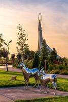 UZBEKISTAN, TASHKENT - SEPTEMBER 15, 2023 Monument of Independence in the form of a stele with a Humo bird on a twilight with dramatic cliods in the New Uzbekistan park. photo