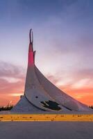 uzbekistán, Tashkent - septiembre 15, 2023 Monumento de independencia en el formar de un estela con un humo pájaro en un crepúsculo con dramático clidos en el nuevo Uzbekistán parque. foto