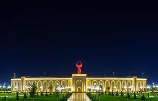 uzbekistán, Tashkent - septiembre 1, 2023 el territorio de el parque nuevo Uzbekistán con Monumento de independencia en el formar de un estela con un humo pájaro a noche. foto