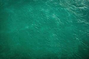 The texture of the waves of turquoise color of fast-flowing water in the river. photo