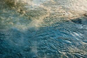 The texture of the waves of turquoise color of fast-flowing water in the river. photo