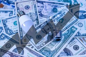 LED lamp and bulb on dollar bills background. photo