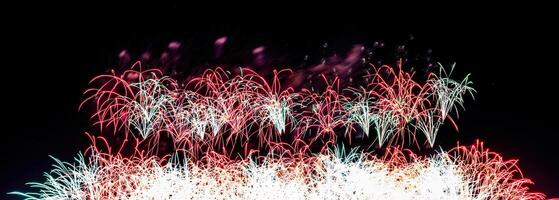 Colorful celebration fireworks isolated on a black sky background. photo