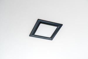 Black rectangular LED lamp isolated on a white ceiling. photo