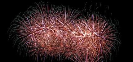 Colorful celebration fireworks isolated on a black sky background. photo