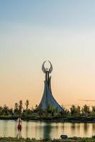 UZBEKISTAN, TASHKENT - SEPTEMBER 15, 2023 Monument of Independence in the form of a stele with a Humo bird on a daytime in the New Uzbekistan park in summer. photo