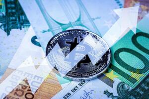 Euro bills and metal souvenir bitcoin. The concept of electronic money and commerce. photo