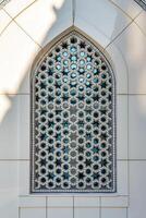 The window of a Muslim mosque behind bars in the form of a geometric hexagonal Islamic ornament. photo