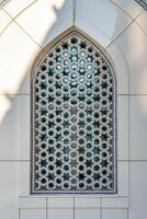 The window of a Muslim mosque behind bars in the form of a geometric hexagonal Islamic ornament. photo